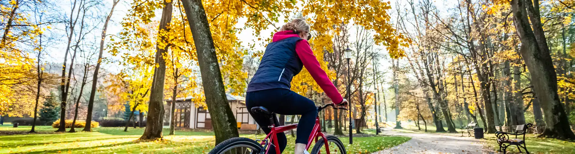 A woman cycling in a park.