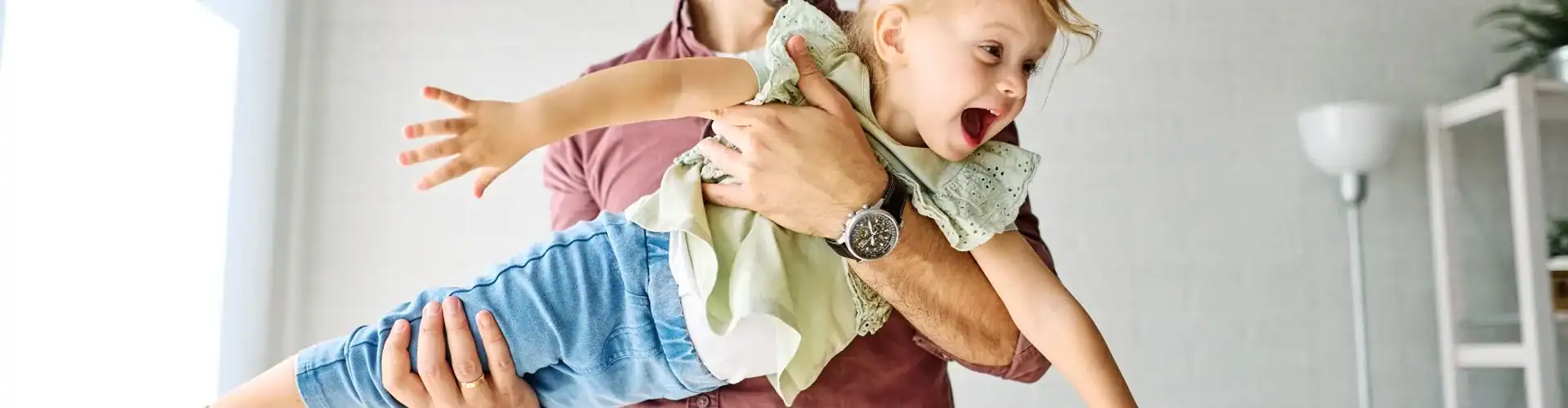 A father playing with his young daughter.