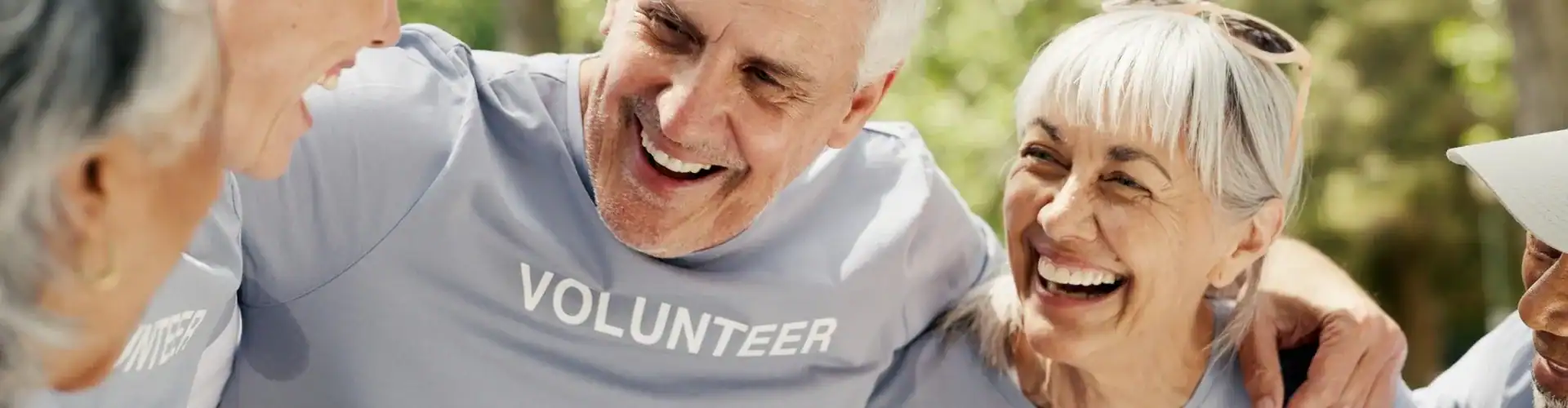 Happy senior people wearing “volunteer” t-shirts.
