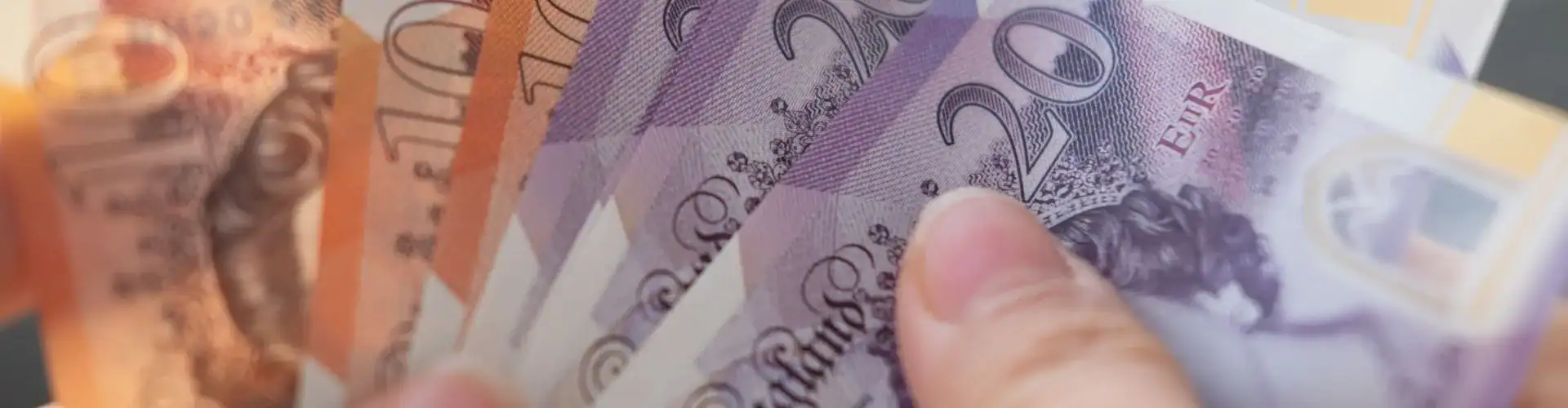 A person holding UK bank notes.